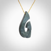 A hand carved large New Zealand Argillite Hook, Matau, necklace. The cord is a tan colour and is adjustable in length. A large sized hand made hook necklace by New Zealand artist Rueben Tipene. One off work of art to wear.